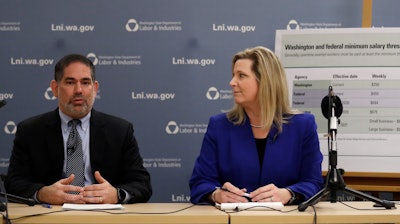 Washington state Labor and Industries Director Joel Sacks, left, and Deputy Director Elizabeth Smith talk about new overtime rules during a news conference, Dec. 11, 2019, in Tukwila, Wash.