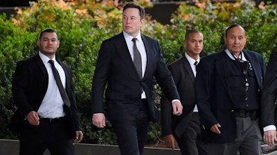 Tesla CEO Elon Musk, second from left, arrives at U.S. District Court Wednesday, Dec. 4, 2019, in Los Angeles. Musk is going on trial for his troublesome tweets in a case pitting the billionaire against a British diver he allegedly dubbed a pedophile.