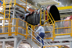 An employee walks up to two of the four rocket engines of NASA's Space Launch System (SLS) as the Artemis 1 rocket core stage is assembled at the NASA Michoud Assembly Center in New Orleans, Monday, Dec. 9, 2019.