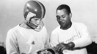 In this, San Francisco 49ers fullback Joe Perry, right, shows quarterback Y. A. Tittle the plastic mask he has worn during the football season to protect his bridgework, during practice at Menlo Park, Calif. Tittle, who suffered a cheekbone fracture against the Detroit Lions, is wearing the mask he has used since. Helmets have evolved from the original hard leather of the NFL’s infancy to hard polycarbonate single-piece shells with various amounts of padding and air bladders that served as the primary form of head protection into the beginning of this century.