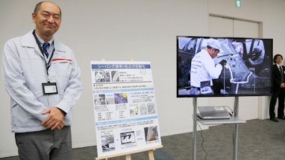 Engineer Makoto Yamada talks to reporters about using robotics for sealing as part of Nissan's new production methods at its 'intelligent factory during a press conference at the company's headquarter Thursday, Nov. 28, 2019, in Yokohama, near Tokyo. Nissan is investing 33 billion yen ($303 million) in its flagship auto plant in Japan's Tochigi prefecture in a first rollout of a production system geared toward electric vehicles.