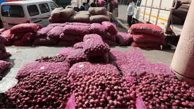 In this Monday, Dec. 16, 2019, photo, bags of onions lie at a market in Ahmadabad, India. Soaring prices has put the humble onion, a staple for most Indian families, out of reach, adding to worries over food inflation at a time when the slowing economy has become a severe liability for Prime Minister Narendra Modi's government. Onion prices are seen by some as a key indicator of economic stability in India, and opposition parties, quick to smell an opportunity, have rallied in the streets wearing onion garlands and offering onions as wedding gifts.