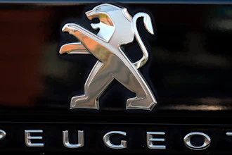 In this Oct. 31, 2019, file photo, a Peugeot logo pictured on a car in Bayonne, southwestern France. Fiat Chrysler Automobiles and PSA Peugeot announced Wednesday, Dec. 18, 2019, that their boards signed a binding deal to merge the two automakers, creating the world’s fourth-largest auto company.