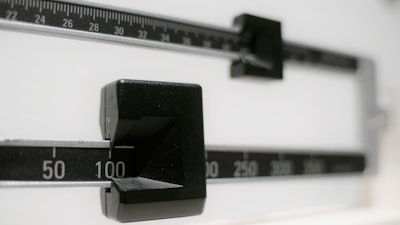 This Tuesday, April 3, 2018 photo shows a closeup of a beam scale in New York. A report released on Wednesday, Dec. 18, 2019 says nearly half of American adults will be obese within a decade and one-quarter will be severely so.