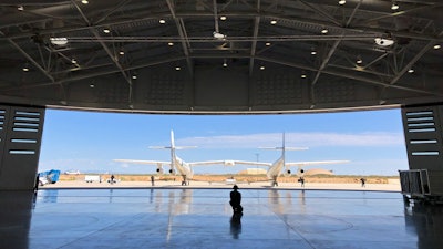 In this Aug. 15, 2019 file photo, Virgin Galactic ground crew guide the company's carrier plane into the hangar at Spaceport America following a test flight over the desert near Upham, New Mexico. Virgin Galactic is on the verge of making more history in 2020 following an 'incredible' year of progress, the chief executive of billionaire Richard Branson's space tourism venture said Thursday.