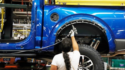 In this Sept. 27, 2018, file photo a United Auto Workers assemblyman works on a 2018 Ford F-150 truck being assembled at the Ford Rouge assembly plant, in Dearborn, Mich. Ford Motor Co. said Tuesday, Dec. 17, 2019, that it is adding 3,000 jobs at two factories in the Detroit area and investing $1.45 billion to build new pickup trucks, SUVs, and electric and autonomous vehicles. At the Dearborn truck plant $700 million will be invested.