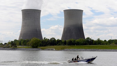 In this April 29, 2015 file photo, a boat travels on the Tennessee River near the Watts Bar Nuclear Plant near Spring City, Tenn. Federal regulators have fined the nation’s largest public utility $145,000 for submitting incomplete and inaccurate information on a backup system at its Watts Bar Nuclear Plant. The Nuclear Regulatory Commission notified the Tennessee Valley Authority of the proposed fine regarding the Spring City, Tennessee plant in a Nov. 19, 2019 letter. The utility says it has taken corrective action, adding that the backup configuration was never used.