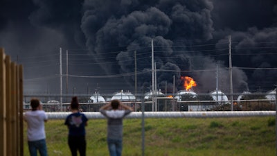Residents observe the fire consuming the TPC Group plant on Wednesday, Nov. 27, 2019, in Port Neches, Texas. Two massive explosions 13 hours apart tore through the chemical plant Wednesday, and one left several workers injured.