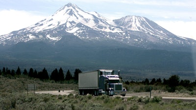 In this June 19, 2008 file photo, a truck drives past Mt. Shasta, near Weed, Calif. California regulators will hold a public hearing on Thursday, Dec. 12, 2019 about whether to require a certain percentage of truck sales to be zero emission vehicles. California has some of the worst air quality in the nation, largely driven by pollution from cars and trucks.