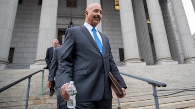 In this Oct. 22, 2019, file photo, Ted Wells, Jr., the lead attorney for Exxon, leaves New York Supreme Court in New York, after opening arguments in a lawsuit against Exxon. Exxon Mobil prevailed Tuesday, Dec. 10, 2019, in a lawsuit accusing the energy giant of downplaying the toll that climate change regulations could take on its business, with a judge saying the state attorney general's case didn't prove the company deceived investors — but also didn't excuse it of any accountability for global warming.