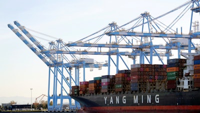 In this Nov. 4, 2019, file photo cargo cranes are used to take containers off of a Yang Ming Marine Transport Corporation boat at the Port of Tacoma in Tacoma, Wash. President Donald Trump says he “will make a decision very soon’’ about whether to impose tariffs on imported cars and auto parts.