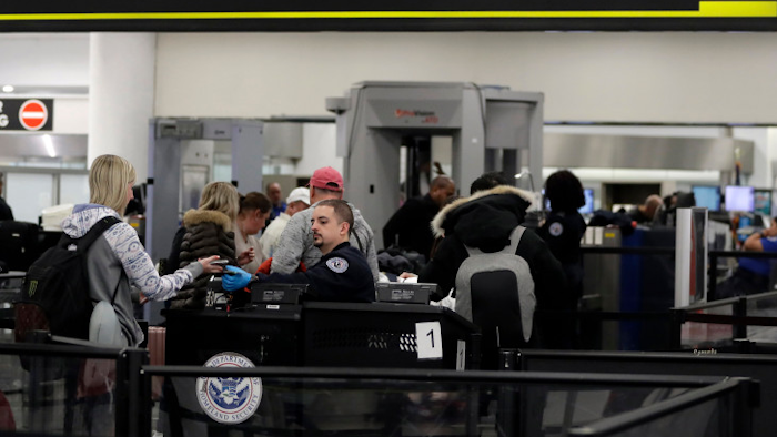 A Transportation Security Administration officer works at the entrance to Concourse G at Miami International Airport, Jan. 11, 2019.