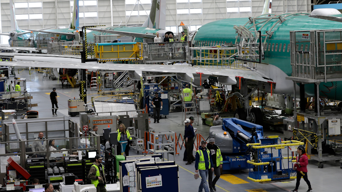 In this March 27, 2019, file photo people work on the Boeing 737 MAX 8 assembly line during a brief media tour in Boeing's 737 assembly facility in Renton, Wash. On Friday, Jan 3, 2020, the Institute for Supply Management, an association of purchasing managers, reports on activity by U.S. manufacturers in December.