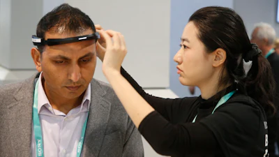 Yuwei Gu, right, of Ampligence, helps Ammad Khan, left, with the BrainCo brainwave-sensing headband before linking with its software platforms, used for education, cognitive performance, and fitness spaces, during the CES tech show Wednesday, Jan. 8, 2020, in Las Vegas.
