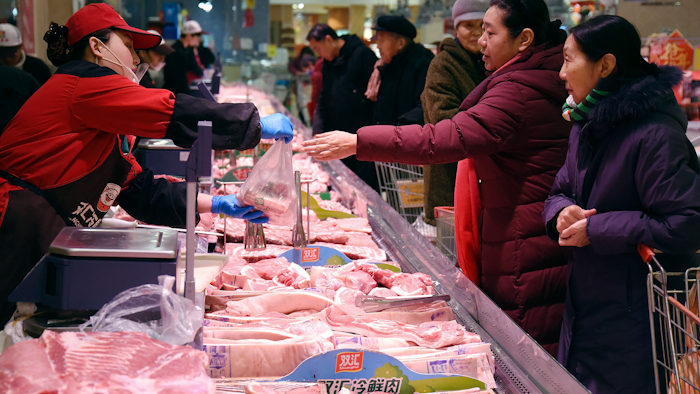 People shop for meat a supermarket in Handan in northern China's Hebei Province, Thursday, Jan. 9, 2020. Soaring pork prices that nearly doubled in December over a year ago kept inflation at a seven-year high despite government efforts to ease meat shortages caused by a disease outbreak, official data showed Thursday.