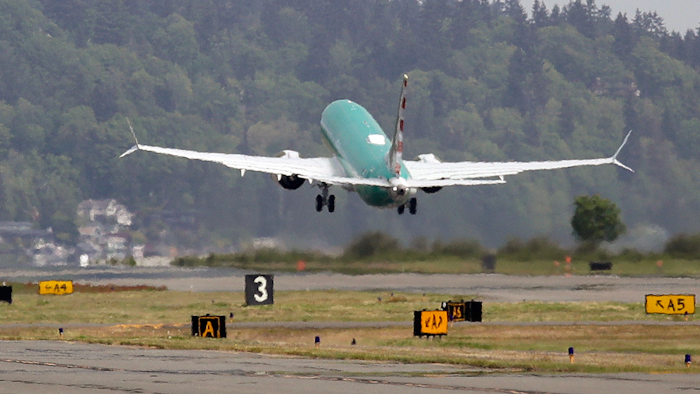 In this May 8, 2019, file photo a Boeing 737 MAX 8, being built for American Airlines, is partially obscured by the engine wash as it takes-off on a test flight in Renton, Wash. A government committee reviewing how the Federal Aviation Administration certifies new passenger planes for flight has determined that the system is safe and effective but small changes need to be made. The committee was appointed by Transportation Secretary Elaine Chao in April after two deadly crashes involving Boeing's 737 Max.