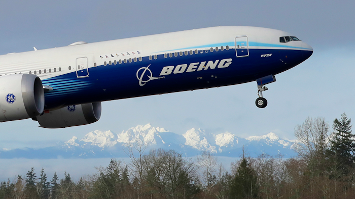 In this Jan. 25, 2020, file photo a Boeing 777X airplane takes off on its first flight with the Olympic Mountains in the background at Paine Field in Everett, Wash. Boeing Co. reports financial results on Wednesday, Jan. 29.