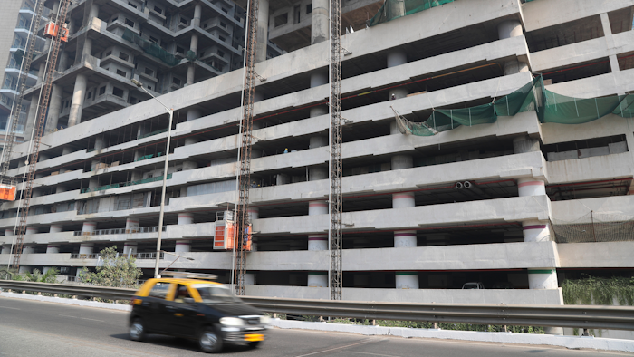 In this Tuesday, Jan. 21, 2020, file photo, a car drives past an under-construction building in Mumbai, India, Tuesday, Jan. 21, 2020. India’s government expects the economy to expand up to 6.5% in the next fiscal year, starting in April, and hopes to follow China's example in developing labor intensive industries and exports.