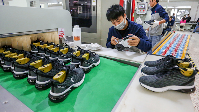 In this Jan. 3, 2020, photo, workers make sneakers in a factory in Jinjiang city in southeastern China's Fujian province. China’s economic growth sank to a new multi-decade low of 6.1% in 2019 as consumer demand weakened and Beijing fought a trade war with Washington. Government data Friday, Jan. 17, showed growth was down from 2018’s 6.6%, already the lowest since 1990. Economic growth in the three months ending in December held steady at the previous quarter’s level of 6%.