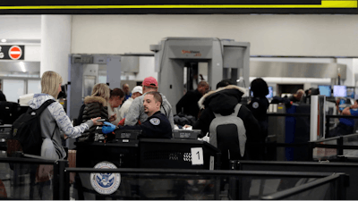 A Transportation Security Administration officer works at the entrance to Concourse G at Miami International Airport, Jan. 11, 2019.