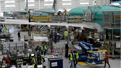 In this March 27, 2019, file photo people work on the Boeing 737 MAX 8 assembly line during a brief media tour in Boeing's 737 assembly facility in Renton, Wash. On Friday, Jan 3, 2020, the Institute for Supply Management, an association of purchasing managers, reports on activity by U.S. manufacturers in December.