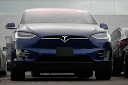 In this Oct. 20, 2019, photo an unsold 2019 Model X sits under a sign at a Tesla dealership in Littleton, Colo. Tesla says its global deliveries rose more than 50% last year meaning the company surpassed the low end of its sales goals for 2019. The electric car maker said Friday, Jan. 3, 2020, that it delivered a record of about 112,000 vehicles in the fourth quarter and about 367,500 for the full year. Tesla previously announced that it expected to deliver 360,000 to 400,000 units worldwide last year.