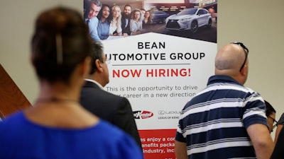 In this Sept. 18, 2019, file photo people stand in line to inquire about jobs available at the Bean Automotive Group during a job fair in Miami. On Friday, Jan. 10, 2020, the U.S. government issues the December jobs report.