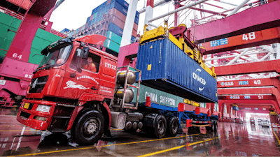 A worker waits to transport containers at the container port in Qingdao in eastern China's Shandong province on Tuesday, Jan. 14, 2020. China's exports rose 0.5% in 2019 despite a tariff war with Washington after growth rebounded in December on stronger demand from other markets.
