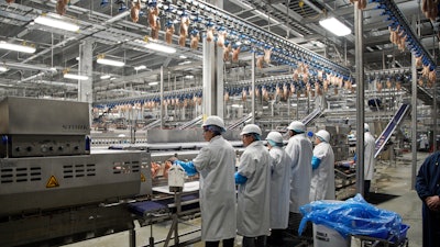 In this Dec. 12, 2019, file photo workers process chickens at the Lincoln Premium Poultry plant, Costco Wholesale's dedicated poultry supplier, in Fremont, Neb. On Friday, Jan. 17, 2020, the Federal Reserve reports on U.S. industrial production for December.