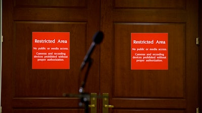 In this Nov. 15, 2019, file photo a microphone stands at the entrance to a secure area during a closed-door interview with David Holmes, a career diplomat and the political counselor at the U.S. Embassy in Kyiv, Ukraine, on Capitol Hill in Washington. The Labor Department will begin restricting news organizations' use of economic data by barring computers from the rooms where reporters receive such data before its public release, department officials announced Thursday, Jan. 16, 2020.