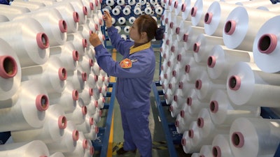 An employee works in a chemical fiber plant in Nantong in eastern China's Jiangsu Province, Friday, Jan. 17, 2020. China's economic growth sank to a new multi-decade low in 2019 as Beijing fought a tariff war with Washington, but forecasters said a U.S.-Chinese trade truce might help to revive consumer and business activity.