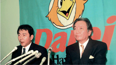 In this December 1998, photo, then Fukuoka Daiei Hawks President Hiroshi Murakami, right, and acting owner Tadashi Nakauchi speak to journalists during a press conference on a suspicion of sign stealing at Fukuoka Dome in Fukuoka, southern Japan.