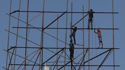 Indian workers repair an advertising hoarding in Hyderabad, India, Tuesday, Jan. 21, 2020. The IMF on Monday lowered India’s economic growth estimate for the current fiscal to 4.8% and listed the country’s Gross Domestic Product (GDP) numbers as the single biggest drag on its global growth forecast for two years.