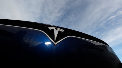 In this Nov. 10, 2019, file photo the company logo shines off the grille of an unsold 2020 Model X at a Tesla dealership in Littleton, Colo.