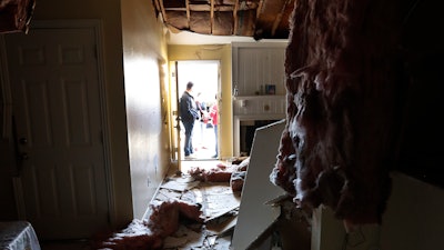 Houston Fire Chief Samuel Peña talks with Hortensia Lima, whose home was seriously damaged and deemed uninhabitable on Stanford Court in Houston, Sunday, Jan. 26, 2020, after the Friday morning explosion at the Watson Grinding Manufacturing plant.