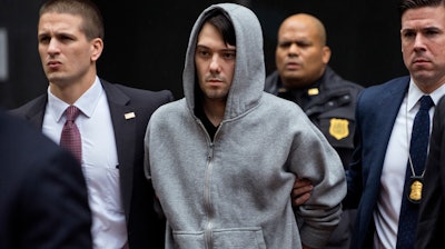 In this Dec. 17, 2015, file photo, Martin Shkreli, center, the former hedge fund manager under fire for buying a pharmaceutical company and ratcheting up the price of a life-saving drug, is escorted by law enforcement agents in New York after being taken into custody following a securities probe. State and federal authorities sued the imprisoned drug entrepreneur Monday, Jan. 27, 2020, over business tactics that helped make him the bad-boy face of profiteering in the pharmaceuticals industry, seeking to bar the so-called 'Pharma Bro' from the industry for life.