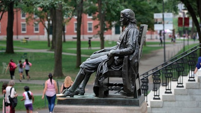 In this Aug. 13, 2019, file photo, the statue of John Harvard sits in Harvard Yard at Harvard University in Cambridge, Mass. Federal prosecutors on Tuesday, Jan. 28, 2020, charged Harvard University professor Charles Leiber, chair of the department of chemistry and chemical biology, with lying to officials about his involvement with a Chinese government-run recruitment program through which he received tens of thousands of dollars.