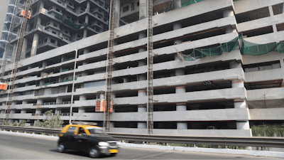 In this Tuesday, Jan. 21, 2020, file photo, a car drives past an under-construction building in Mumbai, India, Tuesday, Jan. 21, 2020. India’s government expects the economy to expand up to 6.5% in the next fiscal year, starting in April, and hopes to follow China's example in developing labor intensive industries and exports.
