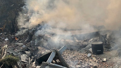 Smoke rises after a factory caught fire and collapsed in Peera Garhi area in western New Delhi, India, Thursday, Jan. 2, 2020. Several people, including some fire officials were injured.