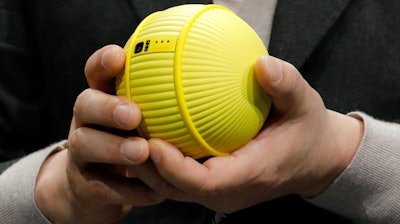 Hyun-Suk Kim, president and CEO of the Consumer Electronics Division at Samsung, holds Ballie, an AI rolling robot during a Samsung keynote before the CES tech show, Monday, Jan. 6, 2020, in Las Vegas.