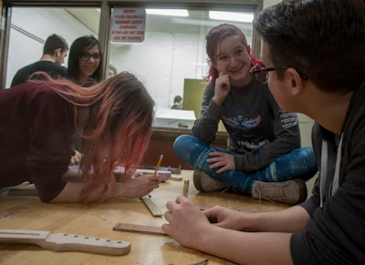 Students work together when they build guitars in class, reinforcing what they learn.