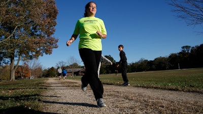 Grace Brown, 14, poses for a portrait while jogging at the park where she does her jogging workouts for her 'online PE' class, in Alexandria, Va., Friday, Nov. 1, 2019. Brown chose to take 'online PE,' utilizing a fitness tracker, so that she could take a piano lab as an extra elective.