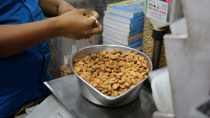 In this June 22, 2019 file photo, a shopkeeper weighs California almonds for a customer at a shop in New Delhi, India. Almonds used to have about 170 calories per serving, then researchers said it was really more like 130. A little later, they said the nuts may have even less. The shifting numbers for almonds show how the figures stamped on nutrition labels may not be as precise as they seem.