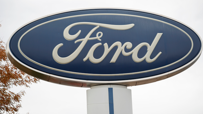 In this Oct. 20, 2019, file photo, the company logo stands over a long row of unsold vehicles at a Ford dealership in Littleton, Colo.