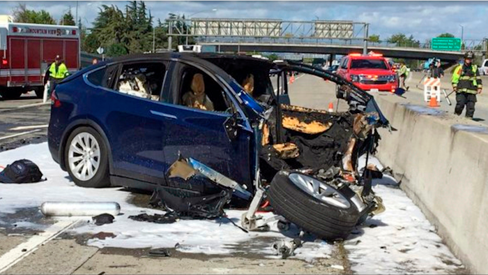 In this March 23, 2018, file photo provided by KTVU, emergency personnel work a the scene where a Tesla electric SUV crashed into a barrier on U.S. Highway 101 in Mountain View, Calif.