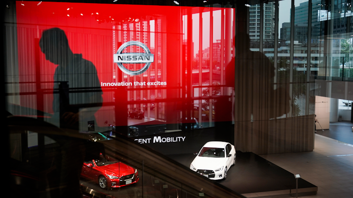 In this July 25, 2019, file photo, a man rides an escalator as Nissan vehicles are showcased in the Nissan Gallery in Yokohama, west of Tokyo.
