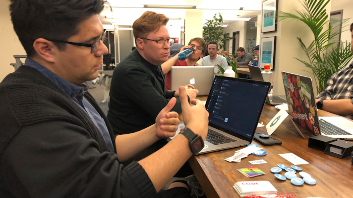 In this Monday, Jan. 13, 2020, photograph taken in Denver, software engineer David Viramontes, front, and digital strategist Patrick Collins direct a meeting of Code For Denver.