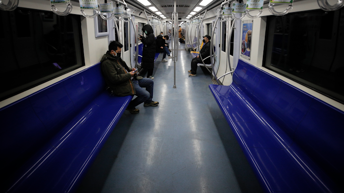 In this Feb. 17, 2020, file photo, commuters ride in a quiet subway train during the morning rush hour in Beijing.