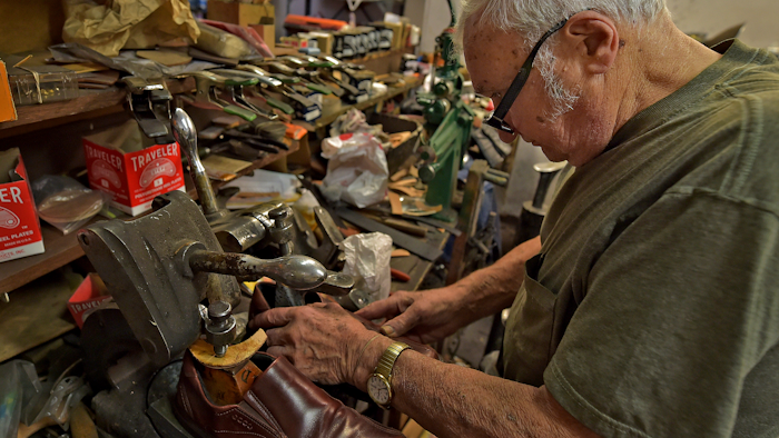 In this Jan. 29, 2020, file photo, Tony Bonczewski repairs a heel on a customer's shoe at his cobbler shop in Wilkes-Barre, Pa. Small business owners have received some upbeat news on the economy this month. Retail sales figures released Friday showed that consumers were inspired by unseasonably warm weather to spend on their homes in January, but that overall sales growth was modest.