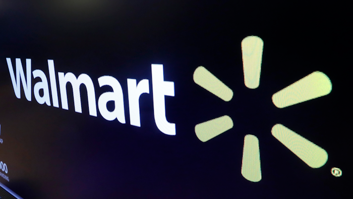 In this Feb. 18, 2020 file photo, the logo for Walmart appears above a trading post on the floor of the New York Stock Exchange. Walmart is confirming that it's developing a competitor to Amazon's juggernaut Prime membership program. The company declined on Thursday, Feb. 27 to offer details, but a spokeswoman said it will be called Walmart+.